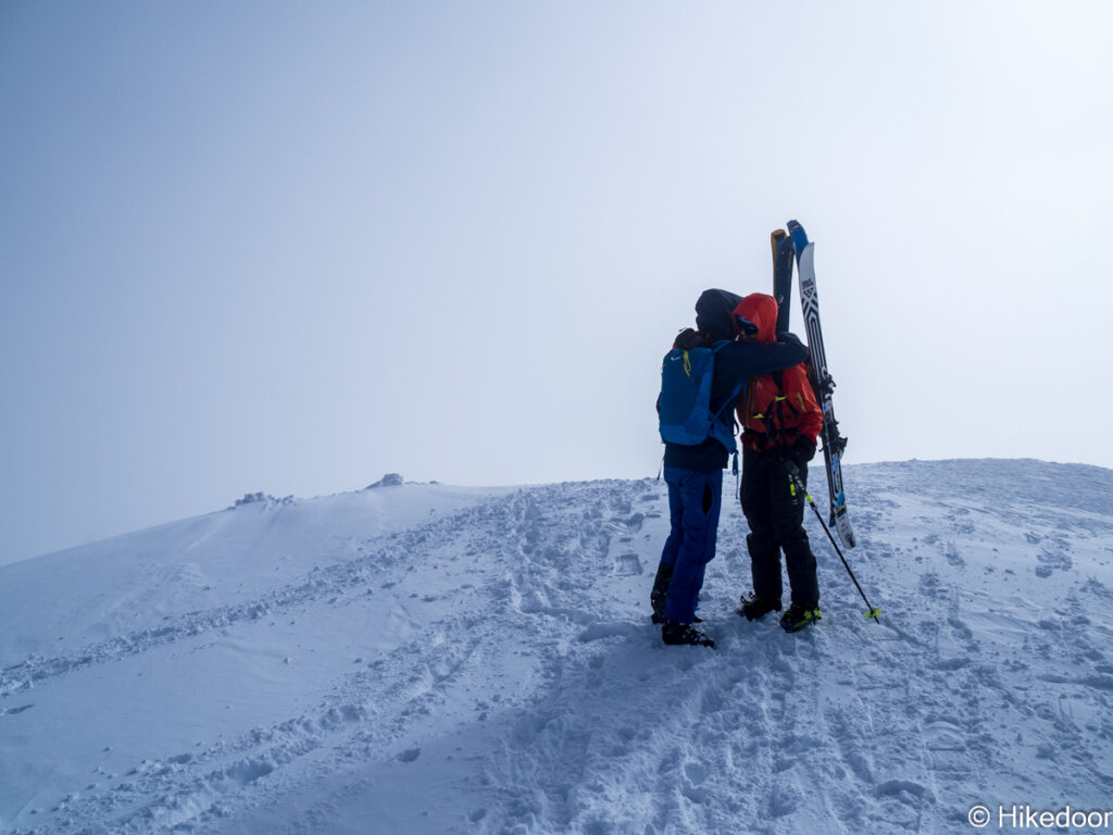 頂上で称えあうスキーヤー